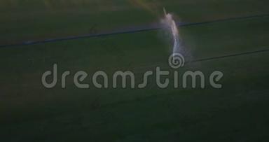空中飞行在马球场上，用大喷头浇草，形成彩虹