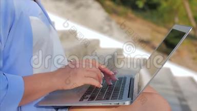 商务女士在笔记本电脑上工作，漂亮的黑发女郎穿着蓝色西装，带着笔记本电脑，漂亮的女人在她的电脑上工作