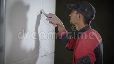 <strong>收缩</strong>工人正在用铲刀在平面上铲平墙壁。