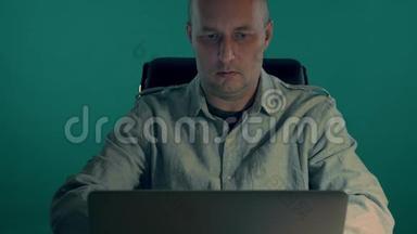 一名身穿衬衫的男警官晚上为笔记本电脑工作。那人把备忘录贴在显示器上。<strong>夜班</strong>特辑