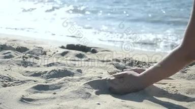女孩坐在海滩上，从<strong>手心</strong>里倒出沙子