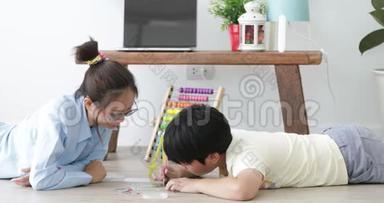 亚洲青少年男孩和他的妹妹一起在家做手工，带着微笑的脸。