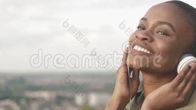 欢快迷人的非洲女人微笑的肖像，戴上耳机，在模糊的地方欣赏音乐
