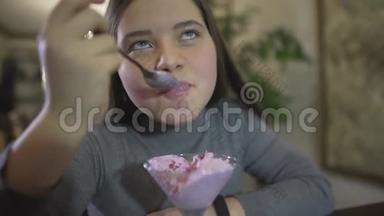 在咖啡馆里用银勺吃紫罗兰色冰淇淋的<strong>胖嘟嘟</strong>的黑发小少女近距离观看