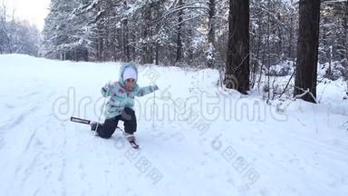 女孩正在学习滑雪。 跌倒后站起来。 她在松软的雪地里慢慢地滑上滑雪板。 美好的一天