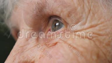 特写老妇人抬头的肖像。 一位有<strong>皱纹</strong>的老太太的<strong>眼睛</strong>。 侧视