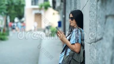 老城区街道背景上智能手机上的美女游客留言