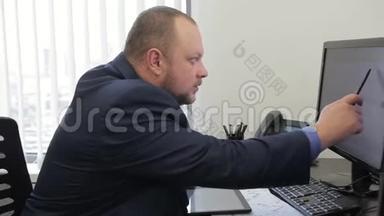 男老板坐在现代<strong>办公室</strong>里<strong>用电脑</strong>和平板<strong>电脑</strong>工作。