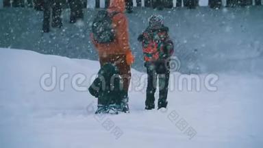 <strong>一家人</strong>的爸爸，妈妈，小儿子和<strong>女儿</strong>骑着雪橇在松树林里下雪。 慢动作