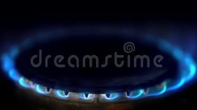 在一个黑暗的厨房里，煤气炉上<strong>点燃</strong>了蓝色的火焰。