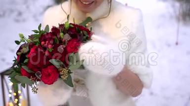 穿着冬衣的新娘，手里拿着一束红玫瑰。