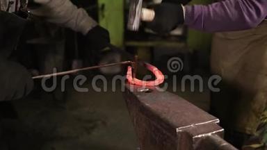 两个铁匠正在锻造铁马蹄铁在一个锻造，特写