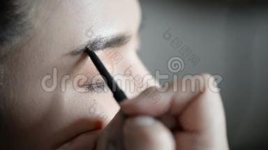 专业化妆师在眼睑上涂抹<strong>眼线笔</strong>