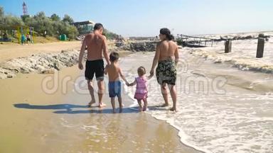 有孩子的年轻家庭在沙滩上<strong>散步</strong>，<strong>手牵手</strong>
