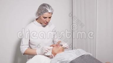 医生美容师给躺在特殊桌子上的病人卸妆