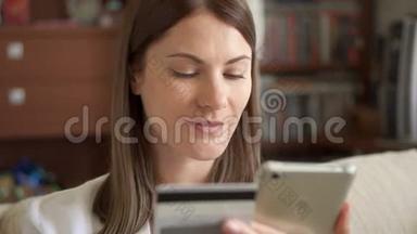 慢动作<strong>女人</strong>穿着白色衬衫坐在客厅沙发上，用智能<strong>手机刷</strong>卡上网