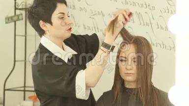女理发师在美容美发店剪发前，在头发上梳理并喷水。 关闭剪发工