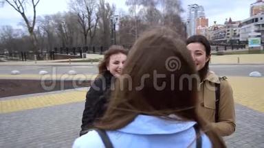 女孩的友谊。 三个年轻漂亮的女孩在街上聊天。 他们很开心。 女孩们很高兴认识