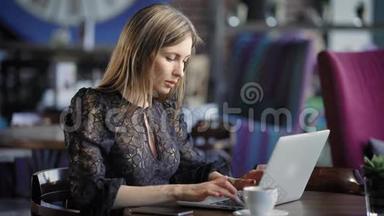一个漂亮的女人在咖啡馆里用笔记本电脑工作。 严肃的商务小姐，午餐休息时在线<strong>点餐</strong>