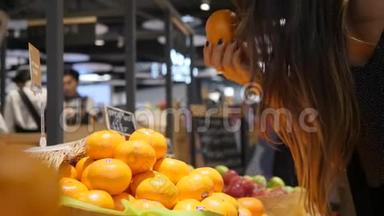 年轻的混合种族妇女采摘橘子水果在<strong>杂货</strong>店<strong>超市</strong>商店。 4K.