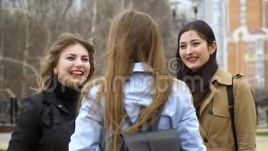 女孩的友谊。 三个年轻漂亮的女孩在街上聊天。 他们很开心。 女孩们很高兴见面。