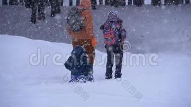 一家人的爸爸，妈妈，小儿子和女儿骑着雪橇在松树林里下雪。 慢动作