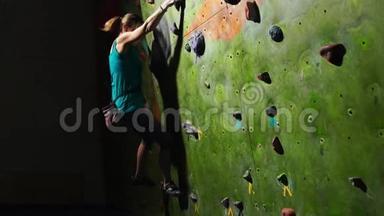 一名女子攀爬者的手特写，她沿着墙壁爬上攀爬墙，在没有比赛的情况下<strong>绊倒</strong>