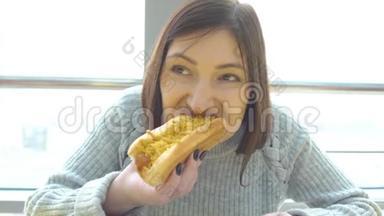 女人在快餐店吃热狗。