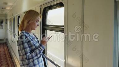 早上在路上。 一个女人在火车上用电话站在窗边