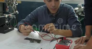 亚洲学生正在学习电子产品，并在教室里测量信号。