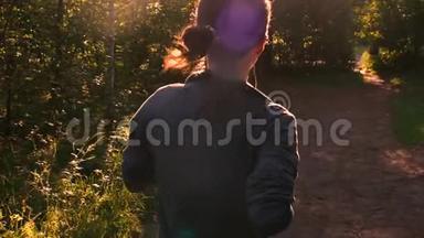 日落时穿过森林的年轻女子。 嘲笑大自然。 慢速运动120fps