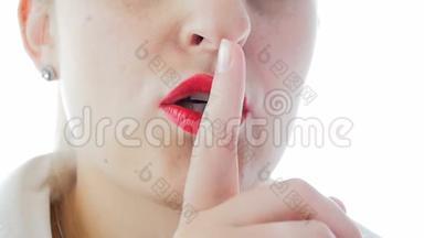 女人用红色口红把手指举到嘴唇上的慢动作视频，要求<strong>保持沉默</strong>或说出秘密