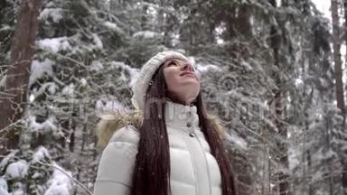 一个<strong>女孩</strong>正在冬天的森林里享受降雪。 一个美丽的<strong>女孩</strong>，长着一头乌黑的长发，穿着一件白色的夹克，在冬天行走