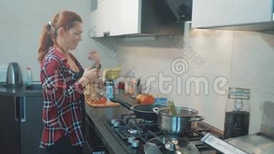 女人在厨房做饭的概念。 女孩把<strong>葵花籽</strong>油倒在格栅上。 女孩妈妈在厨房在室内准备