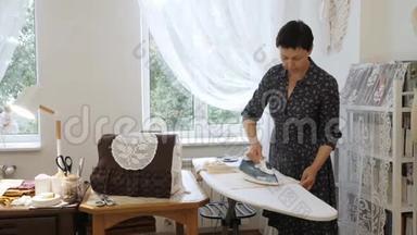 专业的<strong>手工</strong>师傅在她的房间里熨烫织物。 <strong>手工</strong>制作的概念。