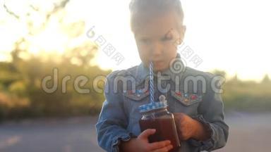 小女孩喝鸡尾酒，果汁，冰沙。 夏日日落时的肖像特写