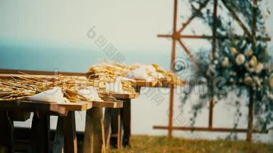 木制的节日拱门在大海的背景上，装饰着秋天的花朵。