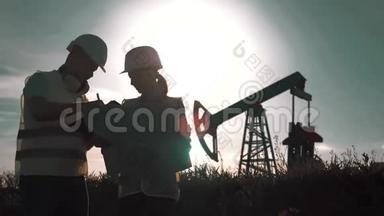 一个团队工程师讨论了一个油泵场的维护。 在炼油厂工作的<strong>工程队</strong>。 两名工人