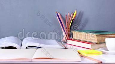 女人把精装书和课本叠在木桌上。