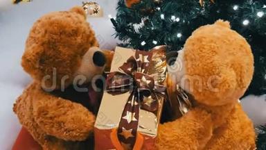有趣的棕色移动泰迪熊，手里拿着一个盒子，爪子里有礼物。 商场的圣诞装饰品