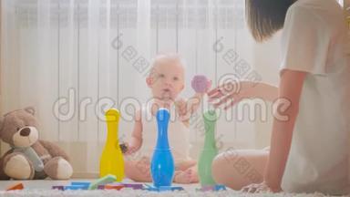 快乐的妈妈和<strong>宝宝</strong>在家里地毯上玩玩具。 侧面<strong>看</strong>一对快乐的母子玩玩具