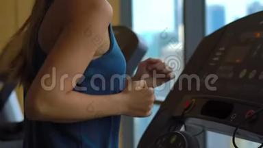 一位年轻女子在一座摩天大楼顶部的健身房里，在跑步<strong>跑道上</strong>训练，观看整个城市的景色