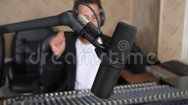 收音机<strong>主持人</strong>在耳机前的音频控制台前的无线电演播室在无焦点<strong>背景</strong>