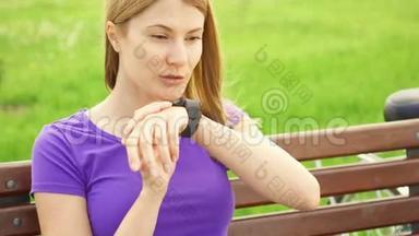 女人在公园里用智能手表发短信。 使用她的智能手表，用语音应用程序向朋友发送信息