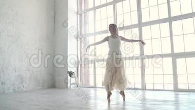 芭蕾舞演员跳古典芭蕾。 穿着明亮的浅色连衣裙的年轻芭蕾舞演员。 慢动作