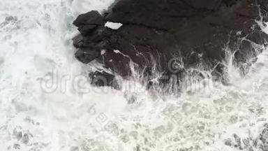 海浪在黑色的岩石上奔跑，破碎成飞溅。