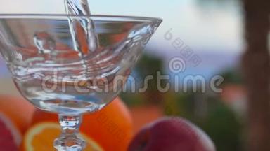 在柑橘类<strong>水果</strong>的背景下，马丁尼被倒入<strong>玻璃杯</strong>中