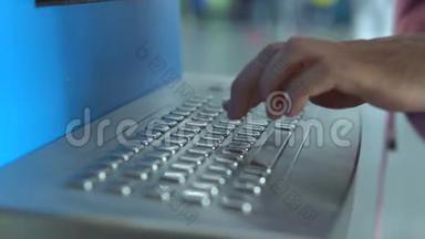 女孩的手在机场值机亭键盘上填写自己的名字，以便在机场候机楼领取机票。