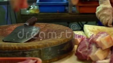 摆摊商用刀在木板上切块猪肉的慢动作。