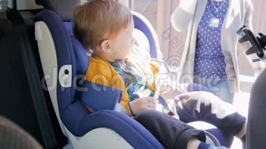4k录像显示，年轻母亲解开安全带，把她的小儿子从儿童安全车上抱出来